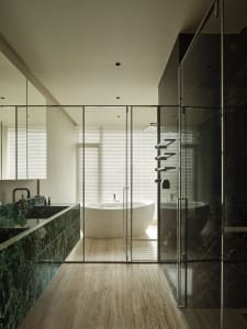 A modern bathroom with marble finishes and a freestanding bathtub.
