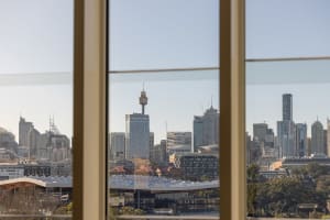 A modern cityscape view from a window, featuring glass and steel skyscrapers.