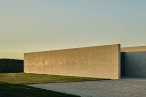 A modern building exterior with a long, smooth concrete wall.
