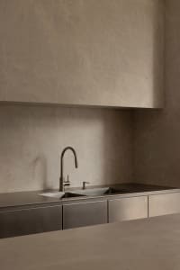 Modern kitchen with metal countertop and stainless steel sink.
