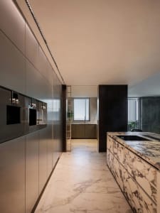 Modern kitchen with marble countertops and floor, sleek design elements.