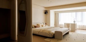 A minimalist bedroom featuring a bed with fabric bedding, a soft, cushioned bench at the foot, and a large window with sheer 