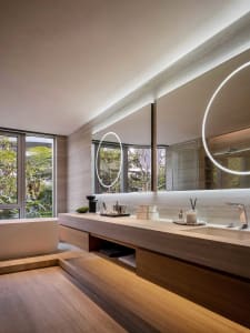 Modern bathroom featuring concrete, wood, and glass materials.