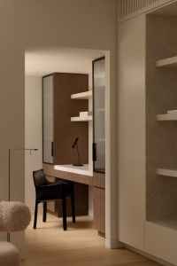 A sleek, minimalist office space featuring a sleek, black chair and a modern, wooden cabinetry system.