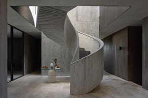 Interior view of a modern industrial staircase with concrete walls and floor.