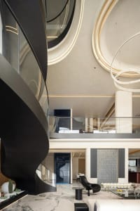A modern living room features a black spiral staircase, marble floor, and minimalist furniture.