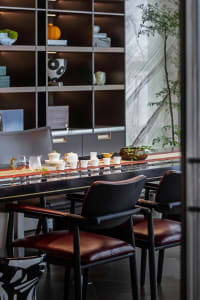 Modern dining room with dark wooden furniture and contemporary decor elements.