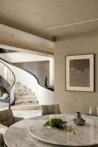 Modern interior with marble dining table, chairs, and abstract art painting.