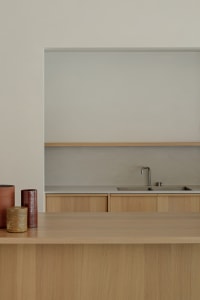 Modern minimalist kitchen featuring wood and concrete materials.
