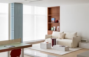 A minimalist living room with a concrete floor, wooden furniture, and marble accents.