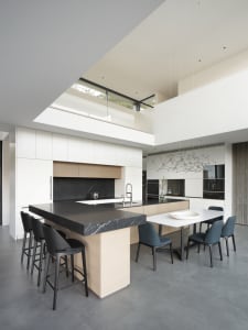Modern residential kitchen featuring a central island with black marble countertop and metallic accents.