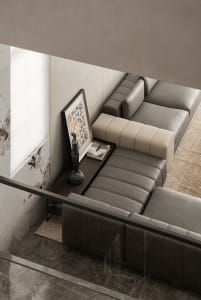 A modern living room featuring a couch upholstered in leather and positioned on a marble floor.