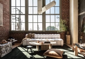 A modern living room with indoor plants, a white sofa, and a hexagonal coffee table.