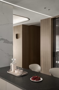 Modern minimalist kitchen featuring marble countertops and wooden cabinets.