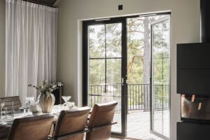 A modern interior scene featuring glass doors with a view of a forested area.