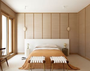 A modern bedroom featuring wooden paneling, a white bed with a wooden headboard, and beige bedding.