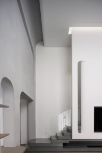 Modern interior design featuring concrete, glass, and wooden elements.