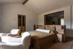 A minimalist bedroom with a wooden bed and fabric bedding.