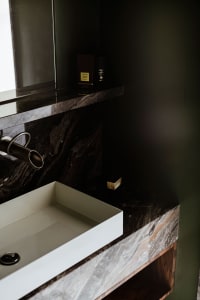 Modern dark marble bathroom with minimalist design and sleek fixtures.