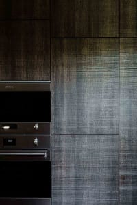 A modern interior with metallic tiles and sleek, dark cabinetry.