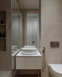 A modern, minimalist bathroom with white porcelain tiling and a sleek, contemporary design.