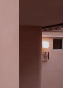A modern interior design featuring concrete walls and circular lighting fixtures.