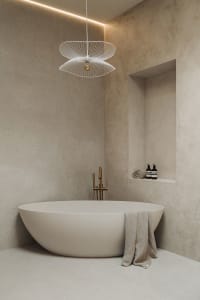 A minimalist bathroom interior with a freestanding bathtub, modern lighting fixture, and concrete walls.