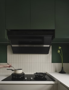 A minimalist residential kitchen with green cabinetry and ceramic tile flooring