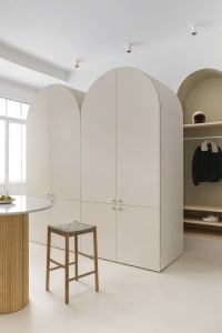 Modern minimalist wardrobe with neutral color materials and white ceiling.