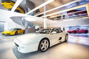 An elegant collection of sports cars displayed in a modern, white marble interior.