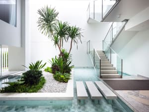 Modern staircase with glass railings and stone steps and landing
