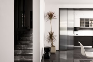 Modern kitchen with black marble countertops and black marble stairs, featuring sleek stainless steel appliances and a minima