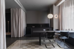 Modern minimalist residential interior with concrete, glass, and beige curtains.
