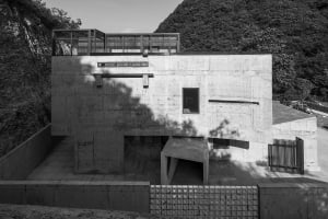 Modern residential house constructed primarily of concrete materials, featuring clean lines and a minimalist design.