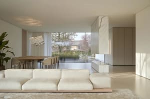 Modern living room featuring a minimalist design with marble elements and a large glass window.
