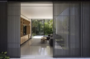 Modern residential space featuring wooden furniture and glass windows.