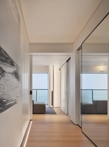Modern residential interior featuring white concrete and wood finishes.