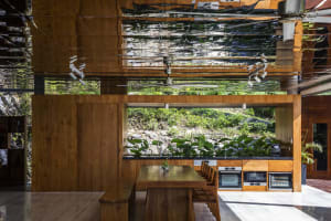 Modern residential kitchen featuring a wooden dining table and chairs, an open-plan layout, and a view of the outdoors with a
