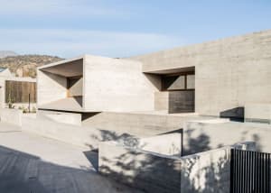 Modern building constructed of concrete with geometric shapes and large windows.