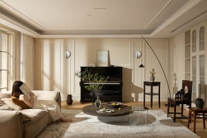 A cozy minimalist living room with a comfortable sofa, wooden coffee table, and a piano against the wall.