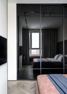 Modern bedroom featuring wooden flooring and metal headboard.