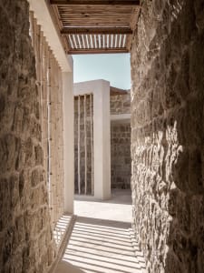 A modern interior space featuring stone columns and a stone wall.