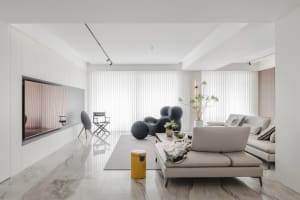 Modern living room featuring a marble floor and white walls with a large window and minimalistic furniture.