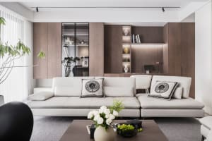 Modern minimalist living room featuring a white sofa, wooden cabinets, and a sleek coffee table.