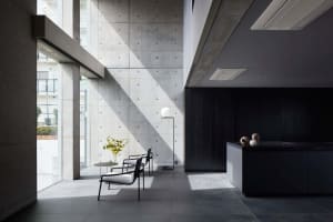A minimalist residential interior featuring concrete walls and a clean, modern aesthetic.
