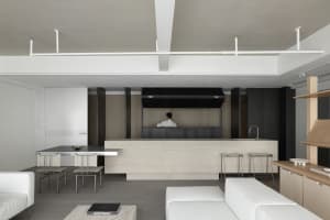Modern, minimalist interior featuring a concrete bar and seating area.