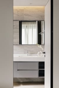 Modern bathroom with marble countertops, glass fixtures, and a minimalist design.