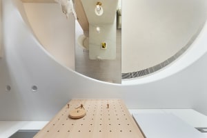 A modern bathroom with wood flooring and minimalistic design elements.