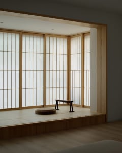 A minimalist interior space featuring paper windows and wooden elements.