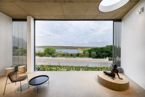 Minimalist residential interior with concrete, glass, and metal elements.